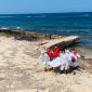 a group of people in white and red uniforms on a beach