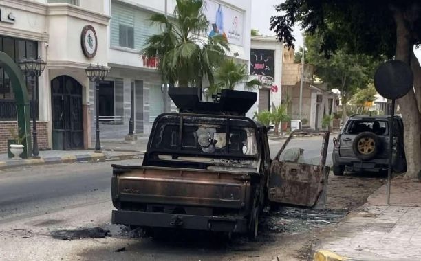 A burned vehicle lies abandoned in a Tripoli street following armed clashes between rival security forces. Source : Social media.