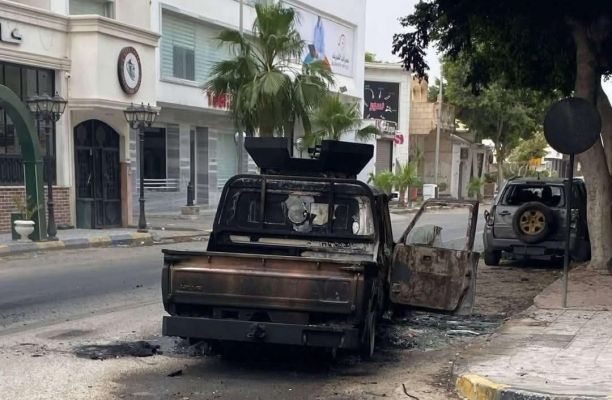 A burned vehicle lies abandoned in a Tripoli street following armed clashes between rival security forces. Source : Social media.