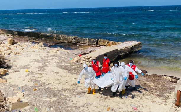 a group of people in white and red uniforms on a beach