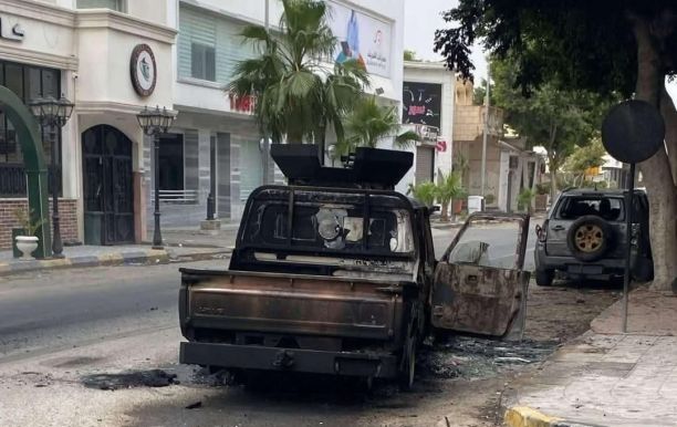A burned vehicle lies abandoned in a Tripoli street following armed clashes between rival security forces. Source : Social media.