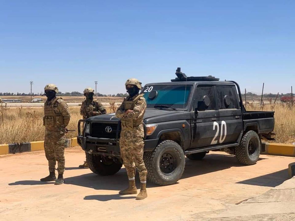 a group of people in military uniforms standing in front of a truck