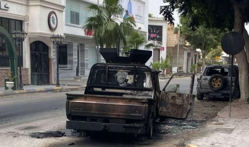 A burned vehicle lies abandoned in a Tripoli street following armed clashes between rival security forces. Source : Social media.