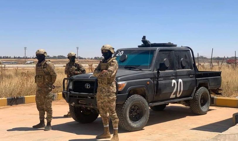 a group of people in military uniforms standing in front of a truck