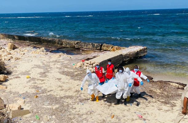 a group of people in white and red uniforms on a beach