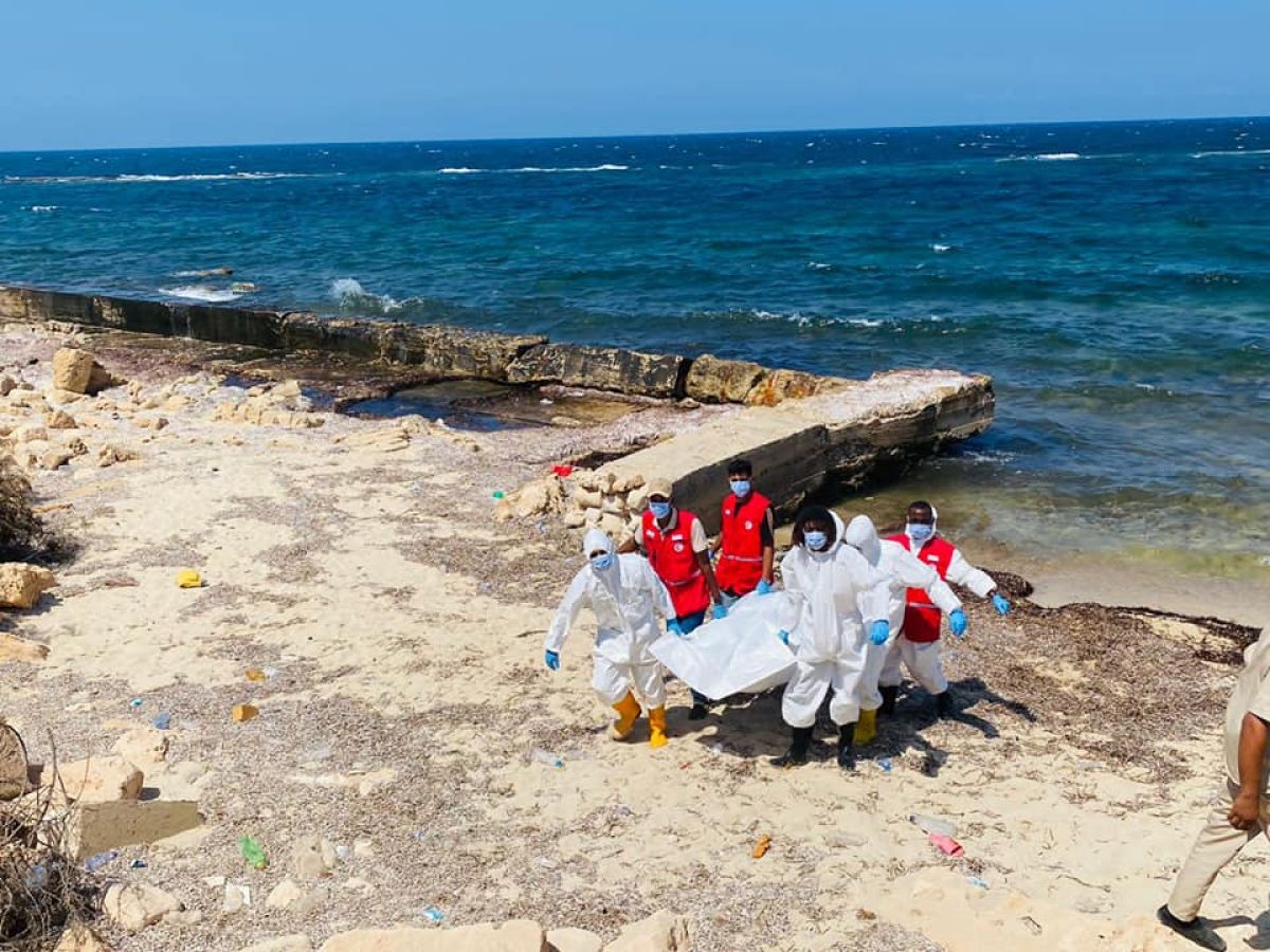 a group of people in white and red uniforms on a beach