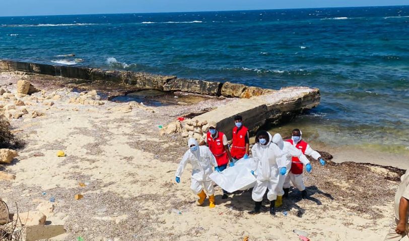 a group of people in white and red uniforms on a beach