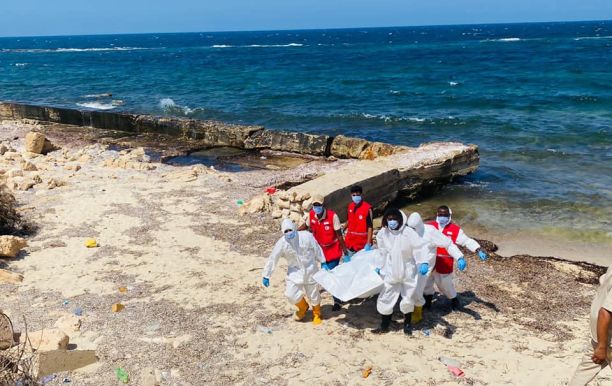 a group of people in white and red uniforms on a beach