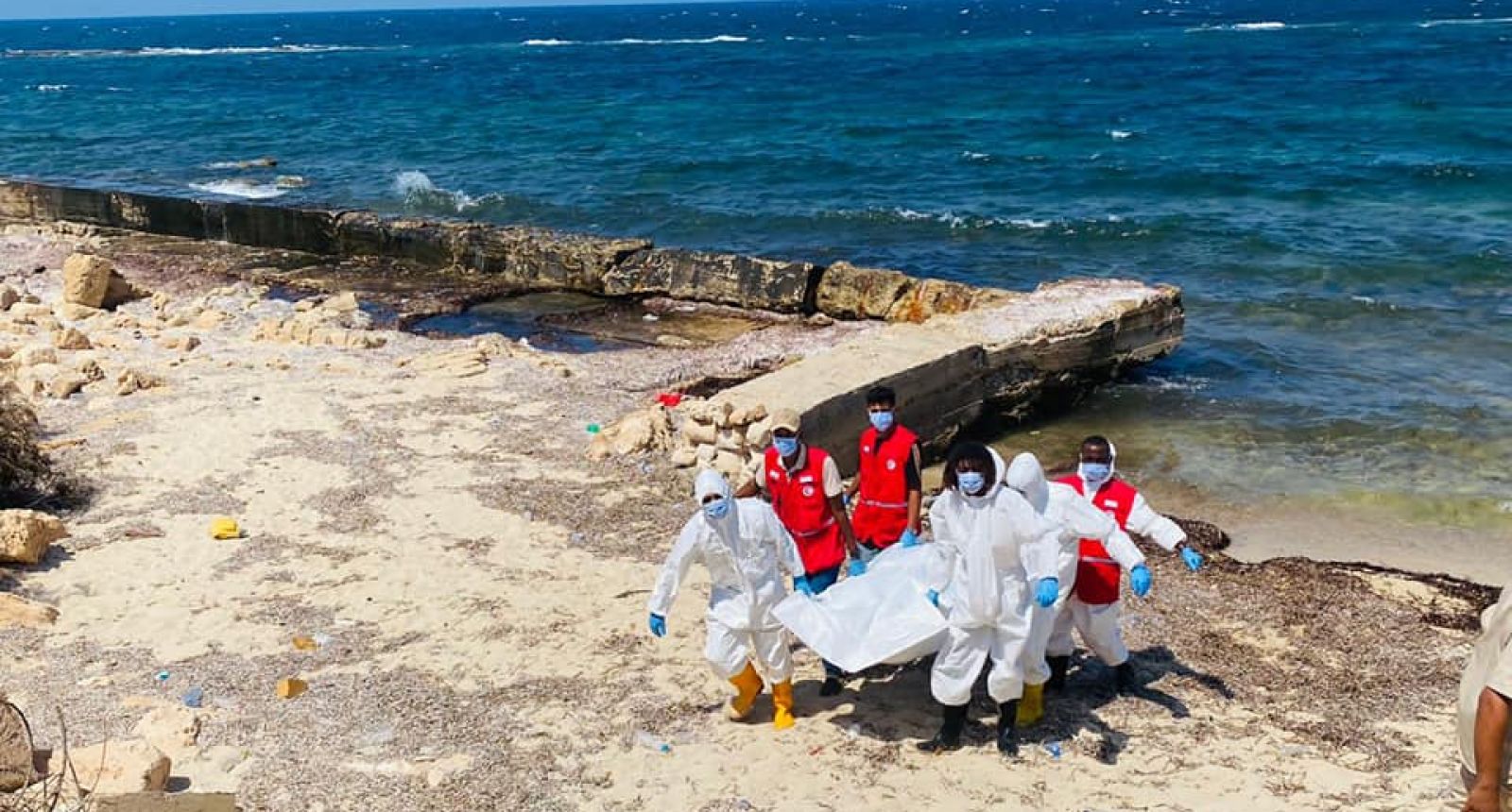 a group of people in white and red uniforms on a beach