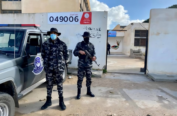 جماعة مسلحة أمام مركز اقتراع في بلدية تاجوراء – المصدر: مواقع التواصل الاجتماعي